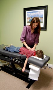 Dr. Dawes doing pediatric chiropractic care on a child